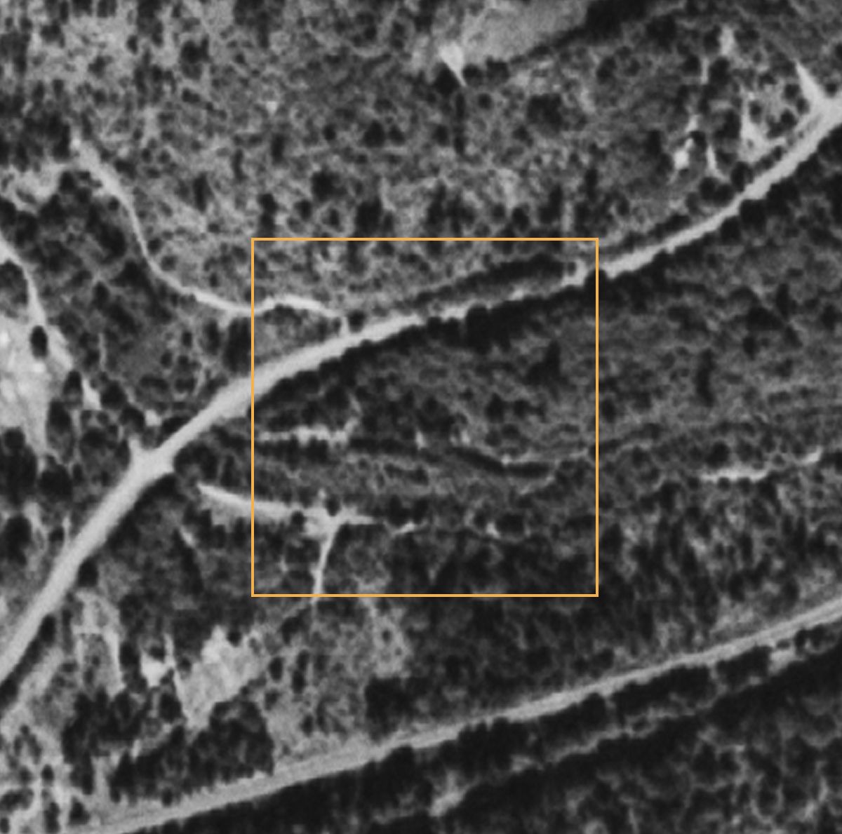 The same square on September 4, 1953: pale tracks branch off the highway into the lower part of the square.